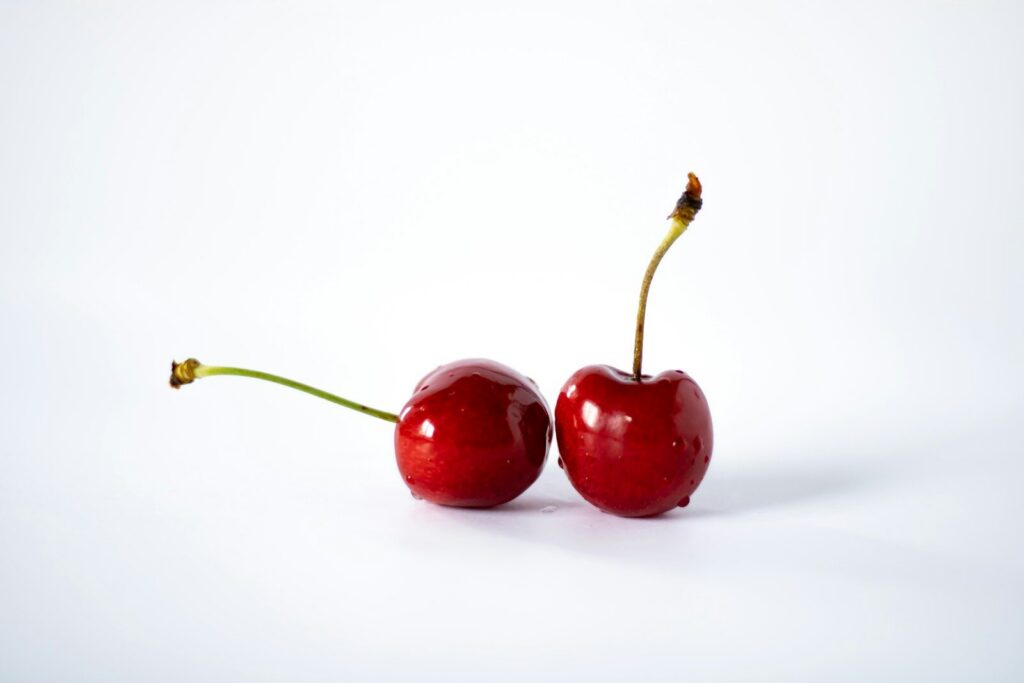 a couple of cherries sitting on top of each other