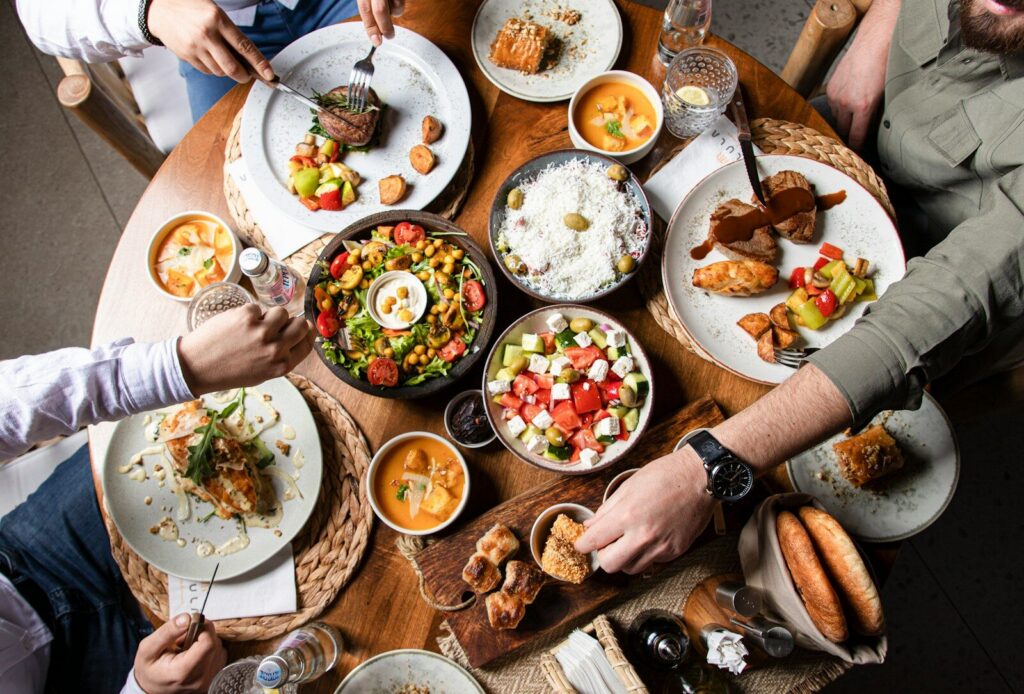 People enjoying a variety of dishes at a round table